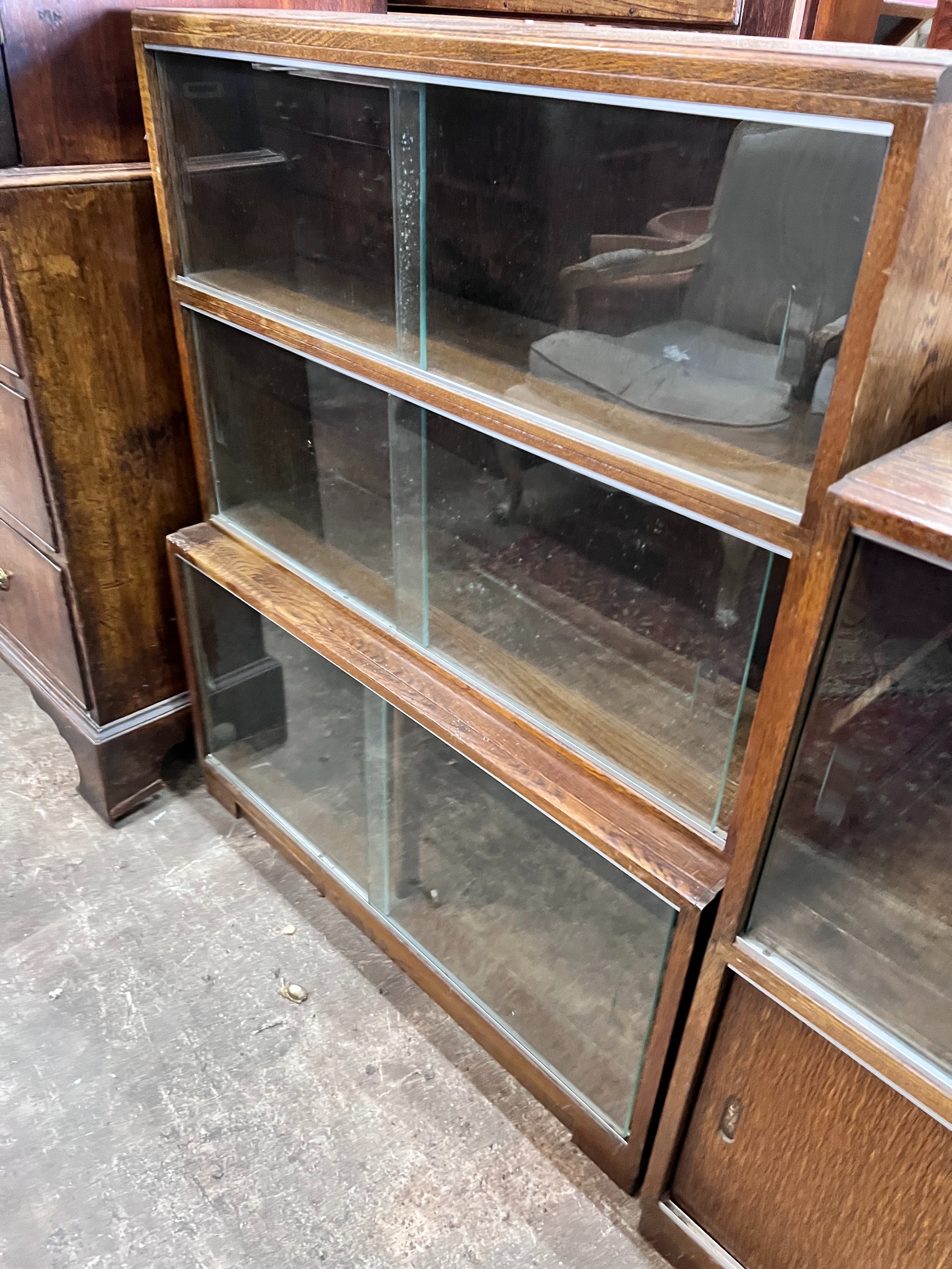 Five 1960's oak Minty bookcases comprising two four section, one three section, and a near pair of two section bookcases, widest 89cm, depth 30cm, height 135cm *Please note the sale commences at 9am.